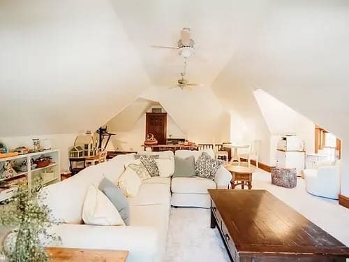 Cozy attic living space with white sofa, wooden coffee table, and bright decor.