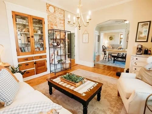 Cozy living room with vintage decor, chandelier, and stylish furniture for a warm ambiance.