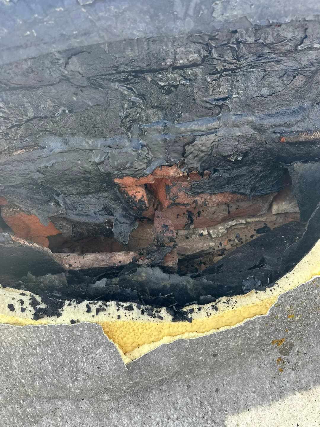 Damaged tire showing exposed inner layers, including brick and foam insulation.