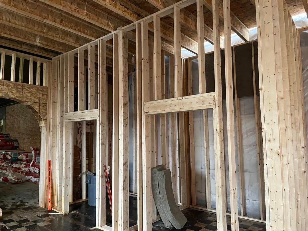 Framed wooden walls in an unfinished construction site interior.